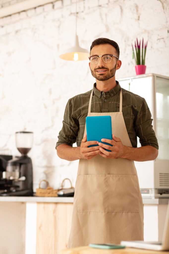 Businessman owning coffee shop wearing apron