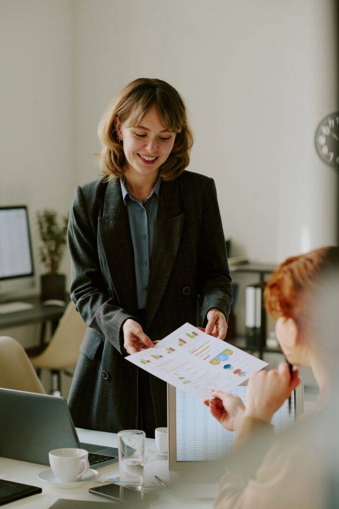 Smiling Businesswoman Discussing Sales Report in Office